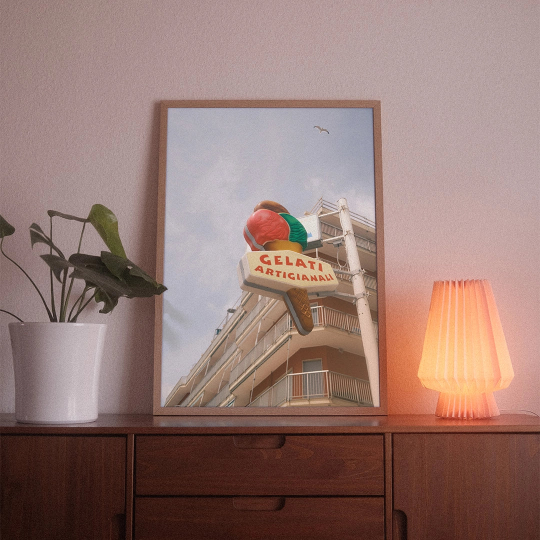 A poster with the photographic motif “Gelati Artigianali” by POWSTR hanging in a living room.