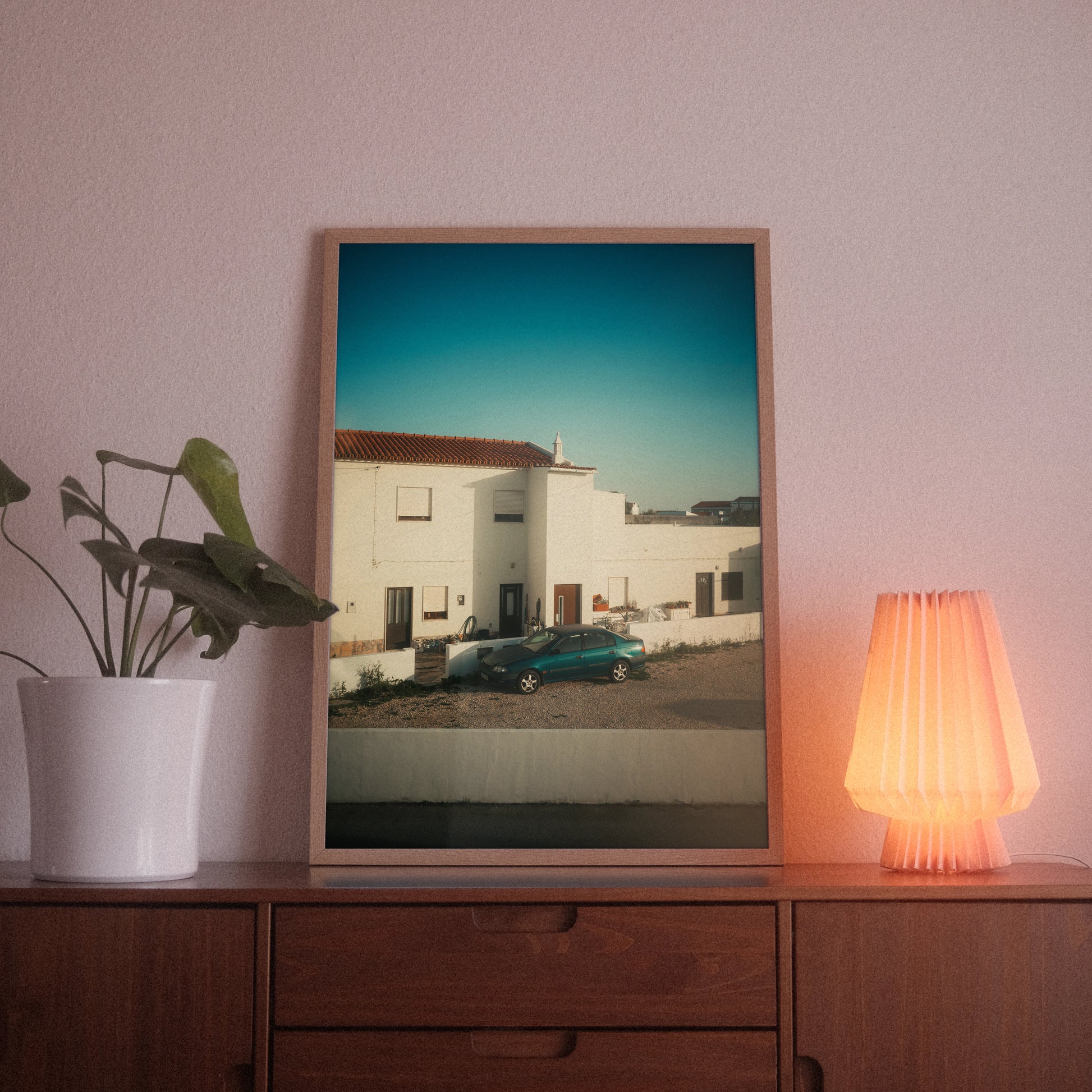 A poster with the photographic motif “Rua Antonio” by POWSTR hanging in a living room.