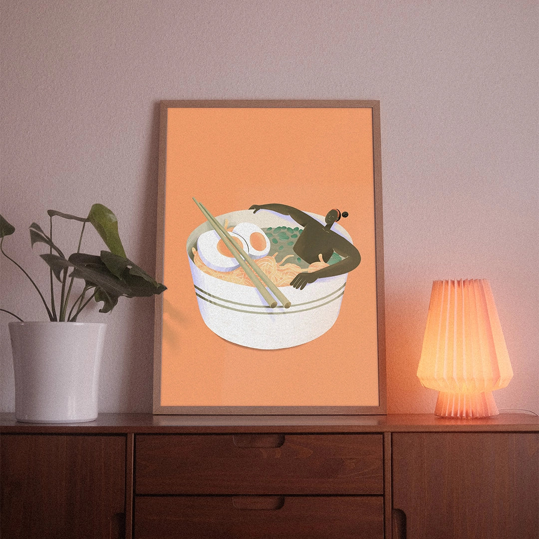 A poster with the illustrative motif “Ramen Bathing” by POWSTR hanging in a living room.